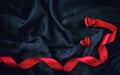 Two red hearts and satin scarlet ribbon on black silk Royalty Free Stock Photo