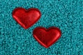 Two red hearts stand in blue small stones Royalty Free Stock Photo