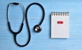 Two Red hearts with stethoscope, blank notepad.