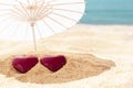 Two red hearts under beach umbrella, blue sky and sea in background. Valentines Day, 14 February symbol. Copy space Royalty Free Stock Photo