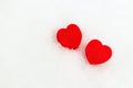 Two red hearts on a white snowy background with copy space. Simple card for Valentine`s Day. Love concept