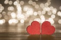Two red hearts on wooden surface with bokeh lights background, on a valentines day concept Royalty Free Stock Photo