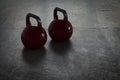 Two red kettlebells on a stone floor in a gym - background light Royalty Free Stock Photo