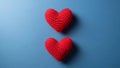Two red knitted hearts on a blue background crochet Royalty Free Stock Photo