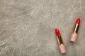 Two red lipsticks on the grey table, top view Royalty Free Stock Photo