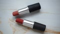 two red lipsticks on a white wooden table Royalty Free Stock Photo