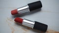 two red lipsticks on a white wooden table Royalty Free Stock Photo