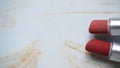 two red lipsticks on a white wooden table Royalty Free Stock Photo