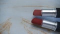 two red lipsticks on a white wooden table Royalty Free Stock Photo