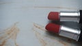 two red lipsticks on a white wooden table Royalty Free Stock Photo