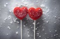 two red lollipops heart shape on grey snowy background top view Royalty Free Stock Photo