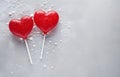 two red lollipops heart shape on grey snowy background top view Royalty Free Stock Photo