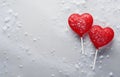 two red lollipops heart shape on grey snowy background top view Royalty Free Stock Photo