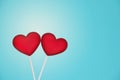 Two Red Lollipops Shape of the Heart on Light Blue Background. Valentine`s Day Concept.