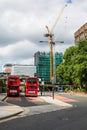 Two Red London Buses Parked in a Town or City Centre Near London