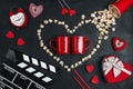 Two red mugs  movie clapper board  popcorn heart  gift box  candles and other love objects on black background Royalty Free Stock Photo