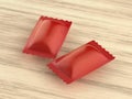 Two red packagings for hard candies on wooden table