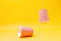 Two red paper cups, with the rope torn off. Children`s homemade toy-walkie-talkie. Yellow background. Copy space. Close up. The Royalty Free Stock Photo