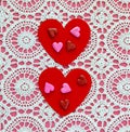 Two red hearts with heart shaped candies on a white doily against a pink background Royalty Free Stock Photo