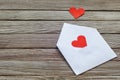 Two red paper hearts on white open envelope against gray wooden background Royalty Free Stock Photo