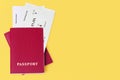 Two red passports, flight boarding passes yellow background close up top view, airline tickets, airplane travel, summer holidays Royalty Free Stock Photo