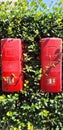 Two red plastic boxes containing fire extinguishers hang on a fence Royalty Free Stock Photo