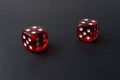 Two red playing dices on black table. Luck and fortune concept