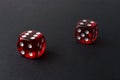 Two red playing dices on black table. Luck and fortune concept