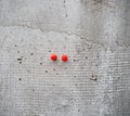 Two Red Push Pins on a wall Royalty Free Stock Photo