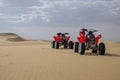 two red quad bikes standing on top of a dune in the desert Royalty Free Stock Photo