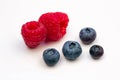 Two Red Raspberries and Four Blueberries Royalty Free Stock Photo