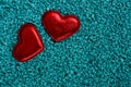 Two red hearts stand in blue small stones Royalty Free Stock Photo