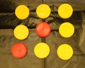 Two red and seven yellow plastic round lid for jars on a black background