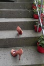 Two red stiletto high heals staning outside on steps of stairs after an party