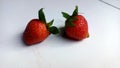 two red strawberries, this fruit tastes sour but there is also a sweet taste.