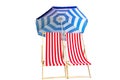Two red striped fabric folding sling beach chairs with blue striped sun umbrella isolated on white Royalty Free Stock Photo