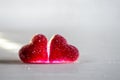 Two red sugar marmalade candies in the shape of heart on a white background, lit from the side, with copyspace Royalty Free Stock Photo