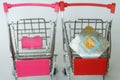 Two red supermarket trolleys, one of which contains an RFID tag. Shoplifting Prevention. Goods security and alarm. Light