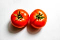 Two red tomatoes on a white background with clear shadows Royalty Free Stock Photo