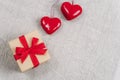 Two red toy hearts and gift box on fabric background. Valentines day concept. Top view, flat lay, copy space Royalty Free Stock Photo