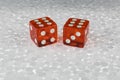 Two red transparent dice on a foam board.