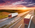 Two red trucks on highway at sunset Royalty Free Stock Photo