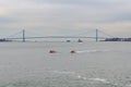 Two United States Coast Guard ships and two industrial ships on Hudson river in front of Verrazano-Narrows Bridge, NYC