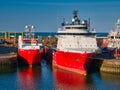 Two red and white offshore industry support / supply ships in Aberdeen Harbour. Taken on a sunny day with blue sky