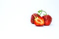 Two whole ripe strawberry berries and one cut on a white background. Royalty Free Stock Photo