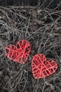 Two red wicker heart, shaped dry dark grass. The contrast of relationships, love and separation. copyspace. Vertical