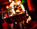 Two red wine glass against christmas lights decoration background