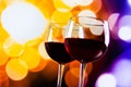 Two red wine glasses against colorful bokeh lights background Royalty Free Stock Photo