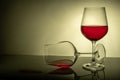 Two red wine glasses on a white background, one glass half full the second lies, spilled wine Royalty Free Stock Photo