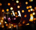 Two red wine glasses on wood table against bokeh lights background Royalty Free Stock Photo
